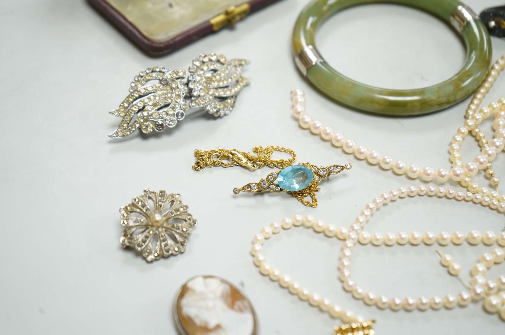 A collection of assorted jewellery including a jade bangle, cultured pearl necklaces and a diamond set yellow metal and quartz ring.